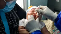 Seorang ibu menggendong bayinya saat petugas kesehatan memberikan vaksin polio di sebuah Pukesmas di Banda Aceh, Aceh, Senin (15/6/2020). Memasuki tatanan normal baru, pelayanan imunisasi anak kembali dibuka setelah sebelumnya sempat terhenti akibat pandemi COVID-19. (CHAIDEER MAHYUDDIN/AFP)