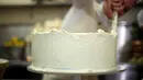 Pemilik Violet Bakery, Claire Ptak menyelesaikan pembuatan kue pengantin Pangeran Harry dan Meghan Markle di dapur Istana Buckingham, London, Kamis (17/5). Harry dan Meghan akan menikah pada 19 Mei mendatang di Windsor Castle. (HANNAH MCKAY/POOL/AFP)