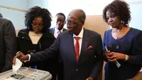 Mantan Presiden Zimbabwe, Robert Mugabe memasukan surat suara di TPS distrik Highfield, Harare, Senin (30/7). Mugabe pertama kalinya memberikan suara dalam pemilihan umum negara itu, setelah dilengserkan November 2017.  (AP/Tsvangirayi Mukwazhi)