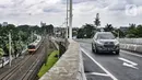 Pengendara mobil melintasi jalan layang atau flyover Lenteng Agung, Jakarta, Minggu (31/1/2021). Uji coba flyover tapal kuda dilakukan sebagai bahan evaluasi di lapangan seperti rambu dan kelengkapan jalan. (merdeka.com/Iqbal S. Nugroho)