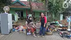 Keluarga ibu Haji Mamah Rusmahwati berpose di depan kediamannya Desa Sumber Urip Pebayuran, Kabupaten Bekasi, Jawa Barat, Senin (22/2/2021). Banjir merenda keluarga tersebut merapikan barang-barang dan bersihkan rumah yang sudah surut. (Liputan6.com/Herman Zakharia)