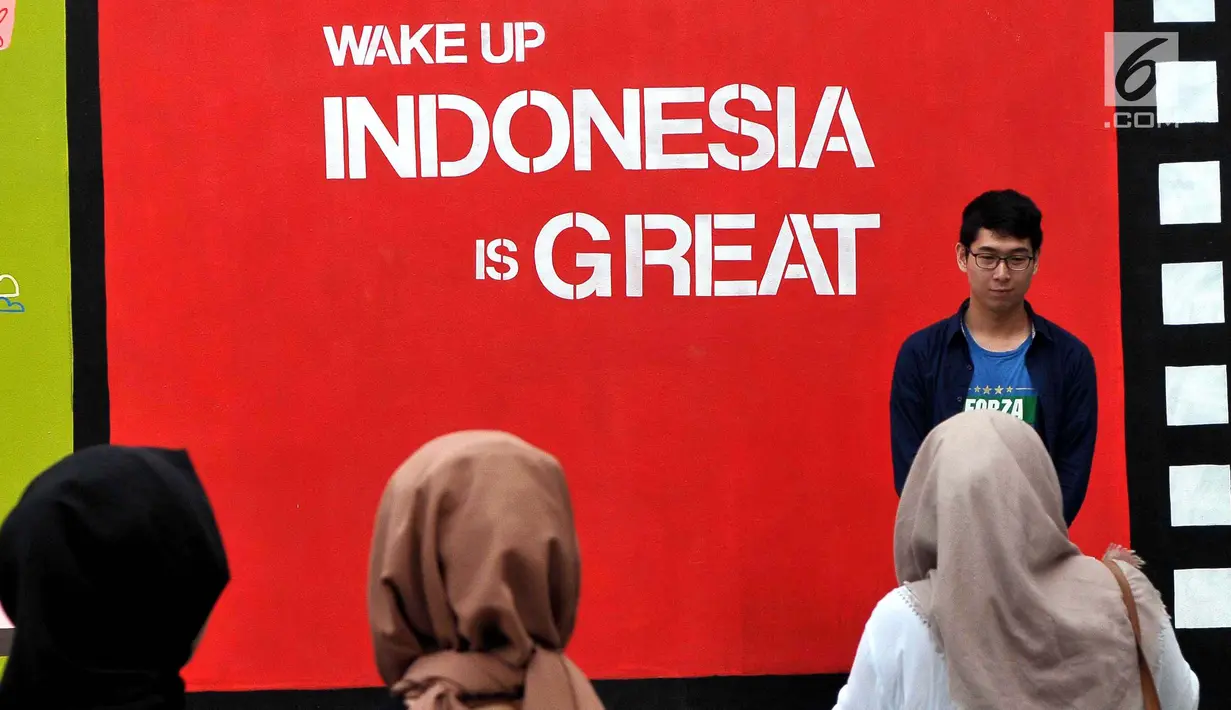 Pengunjung  berpose  di depan mural karya seniman Yogyakarta yang bertajuk INDONESIA IS GREAT, Jakarta, Sabtu (22/7). Pameran ini dalam rangka mewadahi para seniman mural dalam menyuarakan kritik positif maupun negatif. (Liputan6.com/Helmi Afandi)