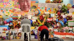 Warga memberikan penghormatan di depan karangan bunga dan kartu ucapan duka meninggalnya Mantan PM Singapura, Lee Kuan Yew di Singapore General Hospital, Senin (23/3/2015). (AFP PHOTO/Mohd Fyrol)