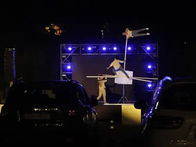 Anggota sirkus tampil secara drive-in di tempat parkir di Seoul, Korea Selatan, Jumat (25/9/2020). Acara ini digelar untuk memberikan hiburan bagi orang-orang selama wabah virus corona. (AP Photo/Ahn Young-joon)