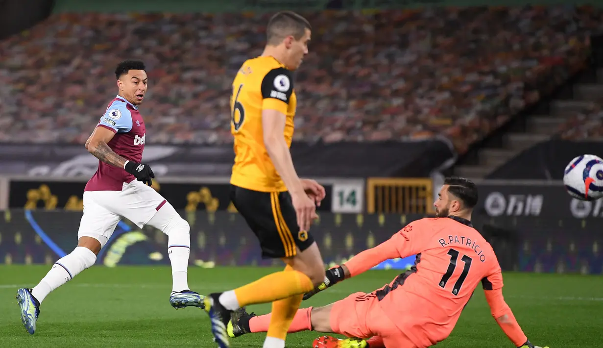 Gelandang West Ham United, Jesse Lingard (kiri) melepaskan tendangan yang berbuah gol pertama timnya ke gawang Wolverhampton Wanderers dalam laga lanjutan Liga Inggris 2020/2021 pekan ke-30 di Molineux Stadium, Senin (5/4/2021). West Ham menang 3-2 atas Wolverhampton. (AFP/Laurence Griffiths/Pool)