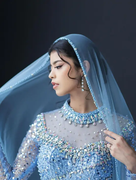 Anting gantung berwarna senada dengan gaunnya mempermanis tampilannya.  [@jharnabhagwani]