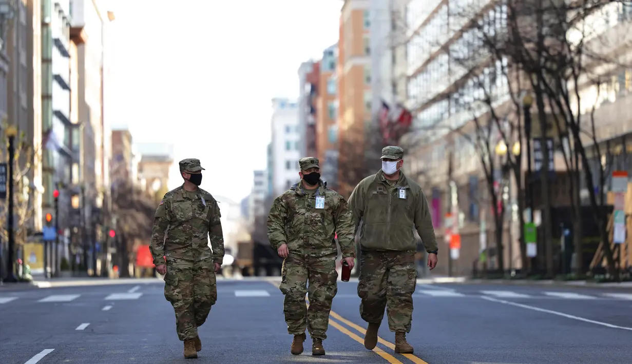 Pasukan Garda Nasional berjalan di sepanjang F Street NW di Washington, DC, Senin (18/1/2021). Menurut laporan, 25.000 tentara Garda Nasional akan menjaga kota tersebut sebagai persiapan untuk pelantikan Joe Biden sebagai Presiden ke-46 Amerika Serikat. (Michael M. Santiago/Getty Images/AFP)