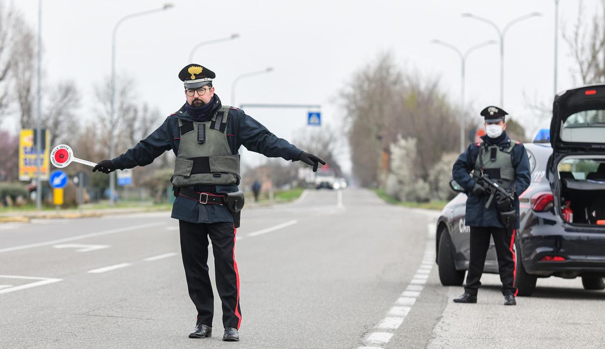 Polisi menjaga perbatasan Modena dan Bologna di Valsamoggia, Bologna, Italia, Senin (9/3/2020). Sebelumnya, pemerintah Italia hanya menutup wilayah utara negaranya untuk menekan penyebaran virus corona (COVID-19). (Piero CRUCIATTI/AFP)