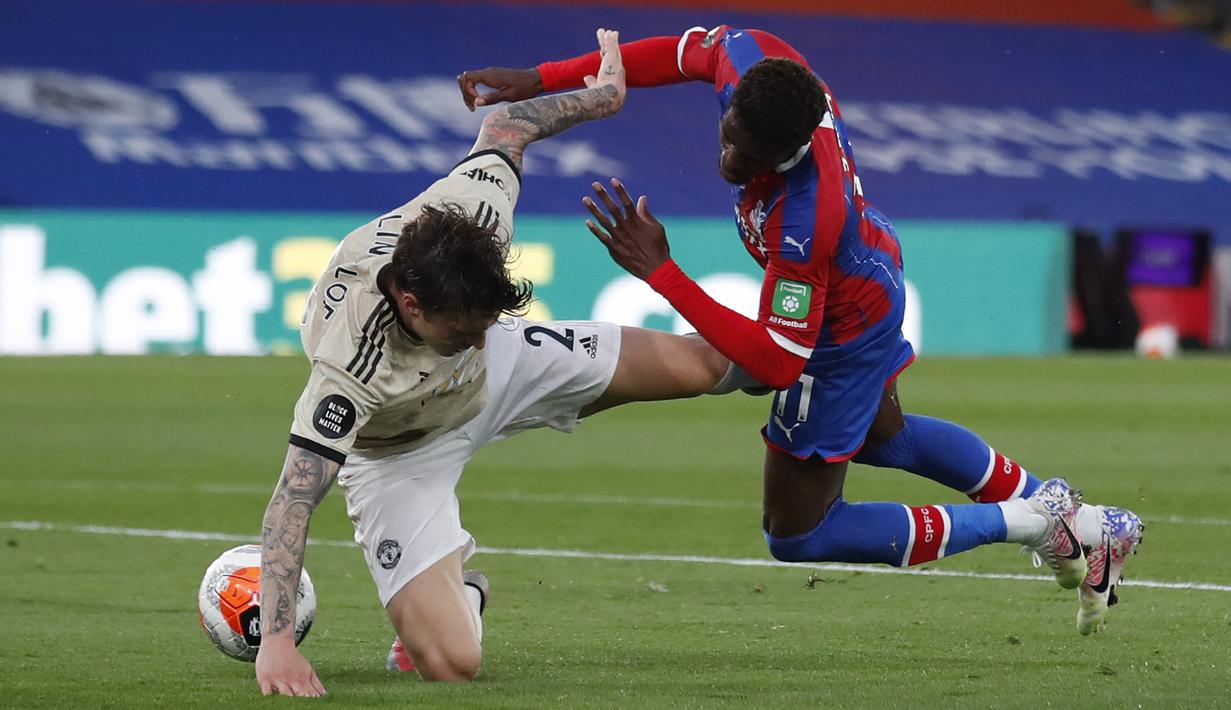 Bek Manchester United, Victor Lindelof, berebut bola dengan striker Crystal Palace, Wilfried Zaha, pada laga lanjutan Premier League di Selhurst Park, Jumat (17/7/2020) dini hari WIB. Manchester United menang 2-0 atas Crystal Palace. (AFP/Peter Cziborra/pool)