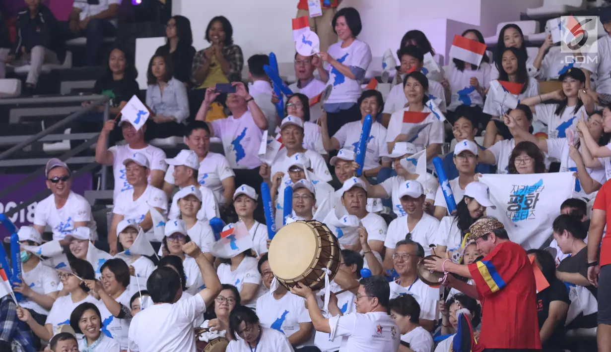 Pendukung tim Korea mengibarkan bendera saat menyaksikan laga basket putri Indonesia melawan Korea pada babak penyisihan Grup X Basket Putri Asian Games 2018 di Jakarta, Rabu (15/8). Indonesia kalah 40-108. (Liputan6.com/Helmi Fithriansyah)