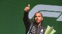 Pembalap Mercedes Lewis Hamilton merayakan kemenangan pertamanya pada Formula 1 Grand Prix di Sirkuit Interlagos, Sao Paulo, Brasil, 14 November 2021. Lewis Hamilton di urutan pertama, Max Verstappen kedua, dan Valtteri Bottas ketiga. (Lars Baron, Pool Photo via AP)