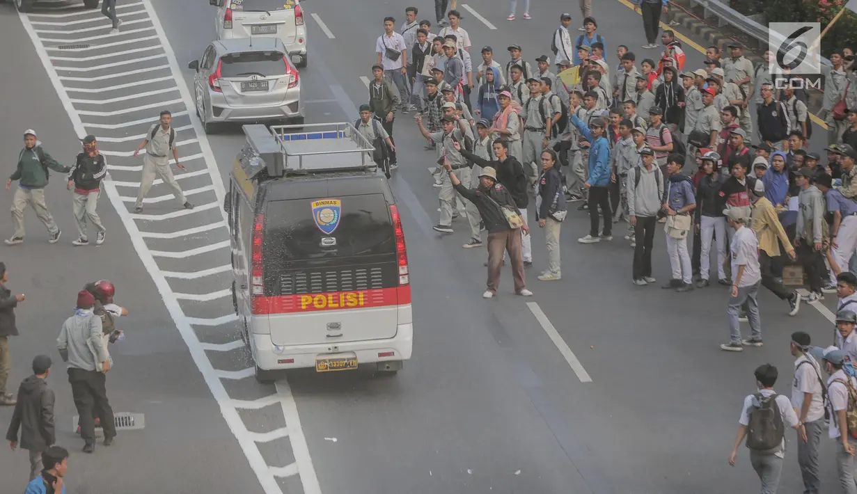 Massa aksi melempari kendaraan dinas milik polisi yang melintasi jalan tol seberang Gedung DPR/ MPR RI, Jakarta, Selasa (24/9/2019). Selain menutup ruas tol, kendaraan dinas pemerintah dan milik polisi jadi korban pelemparan dan perusakan oleh mahasiswa. (Liputan6.com/Faizal Fanani