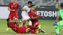 Tiga pemain Timnas Indonesia berusaha menahan pemain Timor Leste pada laga penyisihan grup B Piala AFF 2018 di Stadion GBK, Jakarta, Selasa (13/11). Babak pertama berakhir imbang 0-0. (Liputan6.com/Helmi Fithriansyah)