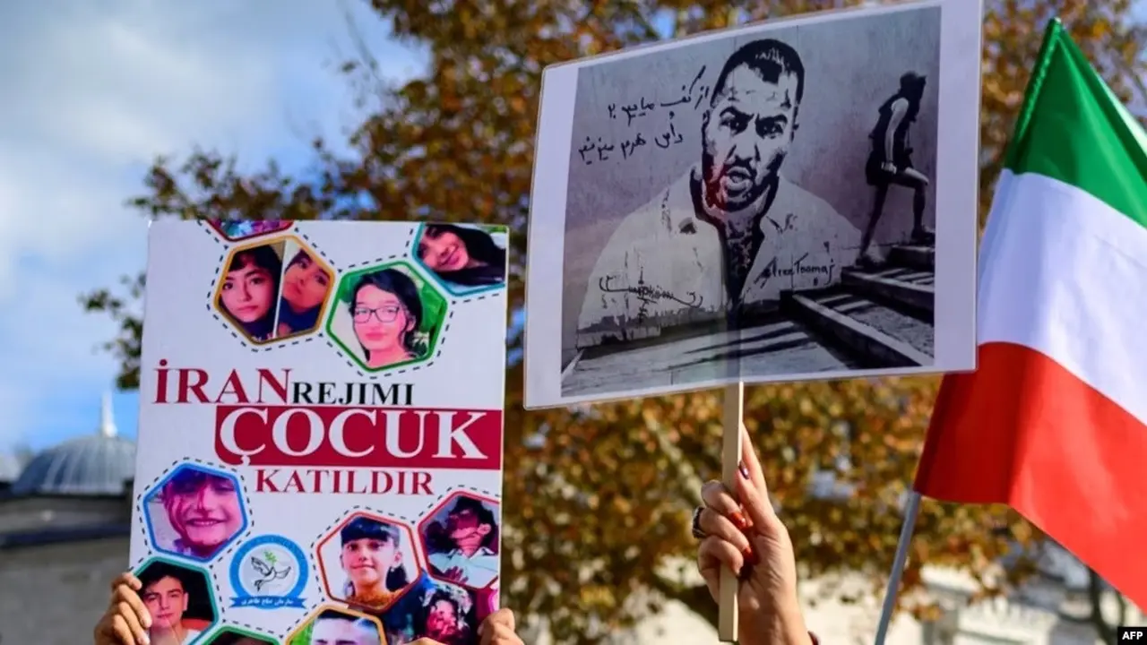 Aksi protes warga di Istanbul, dengan memegang potret rapper Iran Toomaj Salehi (kanan), dan anak-anak (kiri) yang terbunuh selama protes di Iran, 26 November 2022. (File AFP)