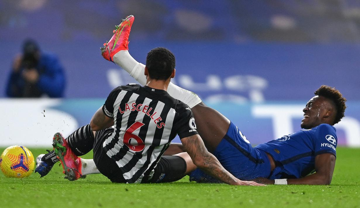 Striker Chelsea, Tammy Abraham (kanan) meringis kesakitan usai dijatuhkan bek Newcastle United, Jamaal Lascelles dalam laga lanjutan Liga Inggris 2020/21 pekan ke-24 di Stamford Bridges, London, Senin (15/2/2021). Chelsea menang 2-0 atas Newcastle. (AFP/Mike Hewitt/Pool)