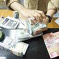 Teller tengah menghitung mata uang dolar AS di penukaran uang di Jakarta, Rabu (10/7/2019). Nilai tukar rupiah terhadap dolar Amerika Serikat (AS) ditutup stagnan di perdagangan pasar spot hari ini di angka Rp 14.125. (Liputan6.com/Angga Yuniar)