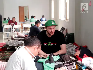 Chief Marketing Officer GO-JEK Indonesia, Piotr Jakubowksi ‎mendampingi salah satu mitra driver GO-JEK yang tengah melakukan kegiatan donor darah yang digelar di Kantor operasional GO-JEK, Jakarta, Senin (14/8). (Liputan6.com/Pool)