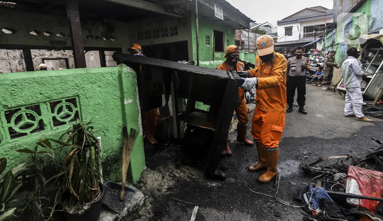 Petugas membersihkan sisa kebakaran di permukiman padat Kelurahan Bali Mester, Jatinegara, Jakarta, Selasa (8/9/2020). Kebakaran di permukiman padat itu melalap 11 rumah tinggal warga serta satu unit bengkel dan mengakibatkan 60 orang mengungsi. (Liputan6.com/Johan Tallo)