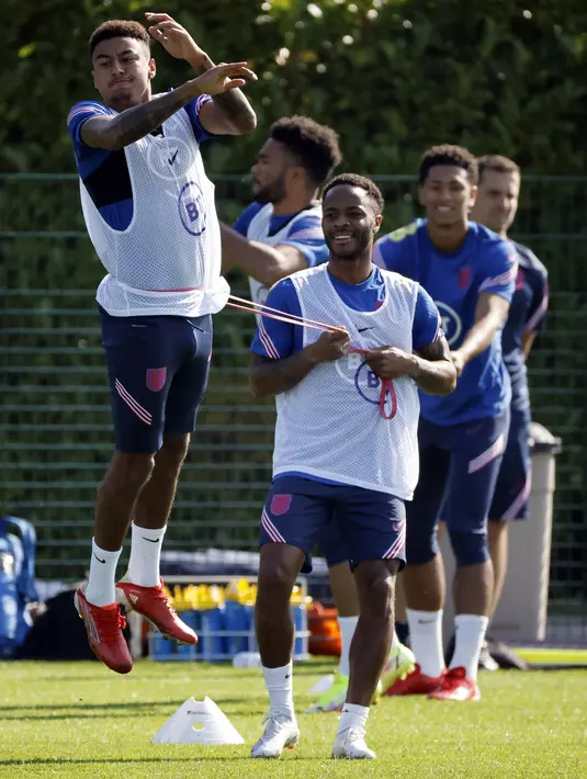 Gelandang Inggris Jesse Lingard dan Raheem Sterling menghadiri sesi latihan di Hotspur Way, di Enfield, London, Selasa (7/9/2021). Inggris akan bertandang ke markas Polandia dalam matchday ke-6 kualifikasi Piala Dunia 2022 zona Eropa Grup I pada 9 September mendatang. (Tolga Akmen/AFP)