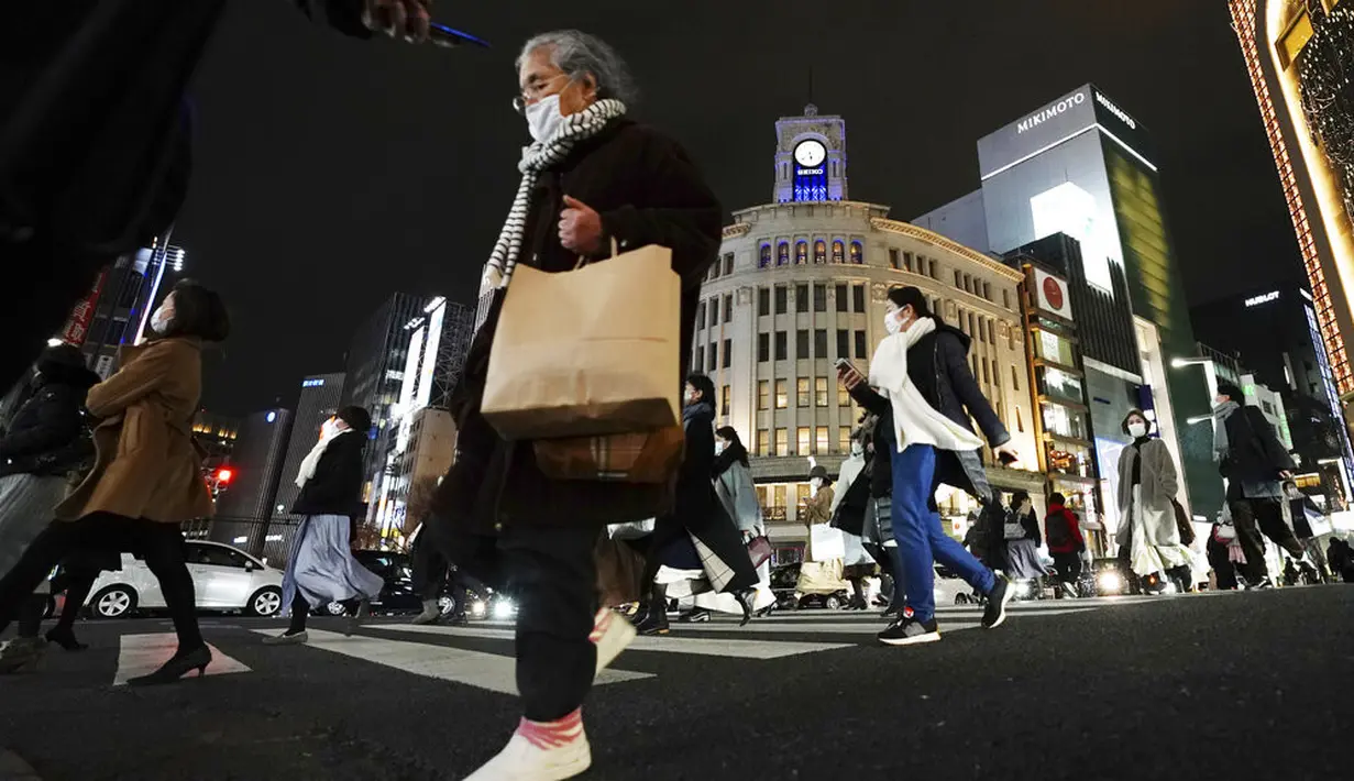 Orang-orang yang mengenakan masker untuk mengekang penyebaran virus corona COVID-19 menyeberangi jalan di kawasan Ginza, Tokyo, Jepang, Rabu (6/1/2021). Ibu kota Jepang itu mengkonfirmasi lebih dari 1.500 kasus baru virus corona COVID-19 pada 6 Januari 2021. (AP Photo/Eugene Hoshiko)