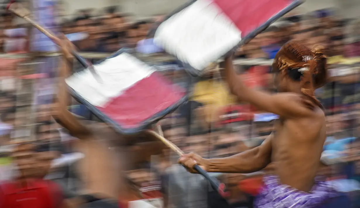 Dua pepadu (petarung) melakukan duel dalam kesenian tradisional peresean di Praya, Lombok Tengah, Selasa (19/2). Masing-masing petarung harus bertelanjang dada, menggunakan kain khas Lombok yang diikat mengelilingi pinggang. (MOH EL SASAKY/AFP)