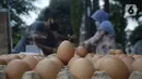 Pedagang telur melayani pembeli di pinggir jalan kasawan Perumahan Nusa Indah, Tangerang Selatan, Banten, Jumat (22/5/2020). Jelang Lebaran, harga telur eceran terpantau masih normal. (merdeka.com/Dwi Narwoko)