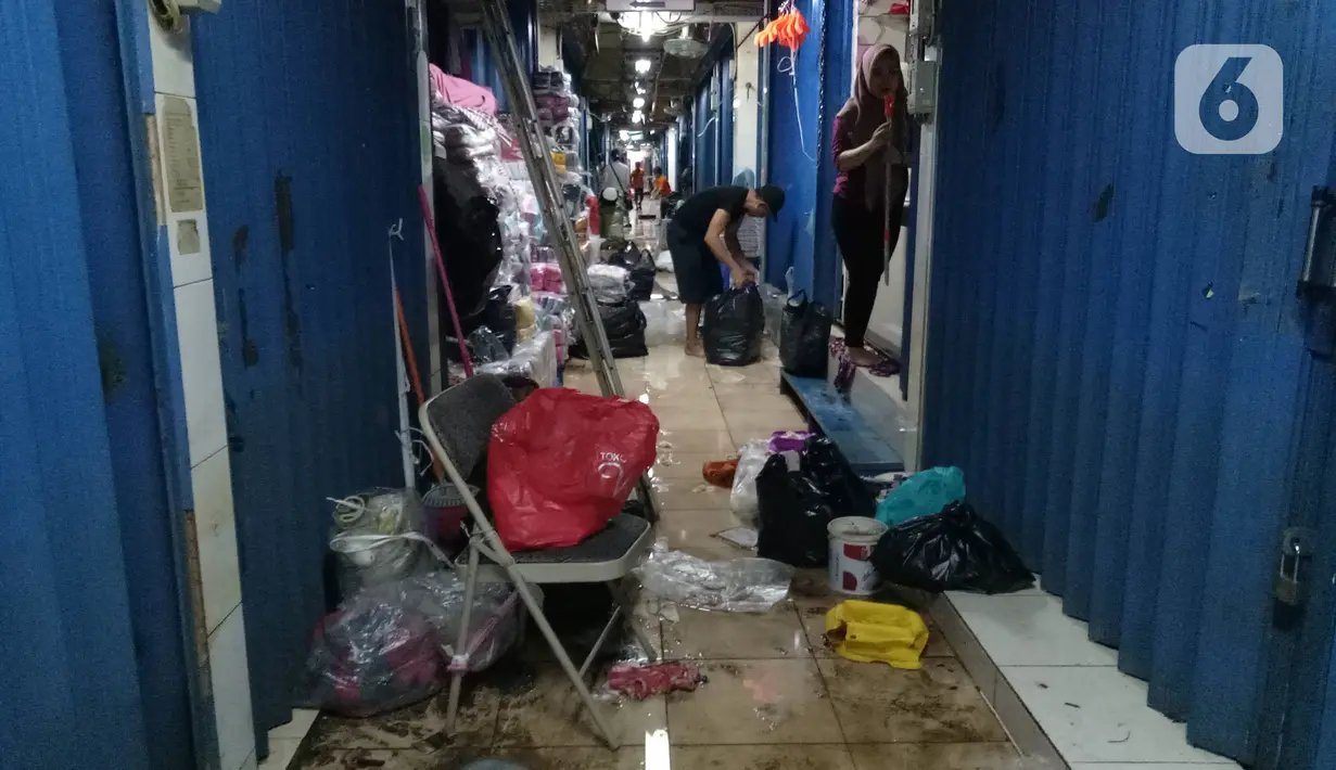 Para pedagang merapikan toko mereka usai banjir merendam Pasar Cipulir, Jakarta, Jumat (3/1/2020). Meski banjir telah surut, akitivitas jual beli di Pasar Cipulir masih belum kembali normal. (Liputan6.com/Angga Yuniar)