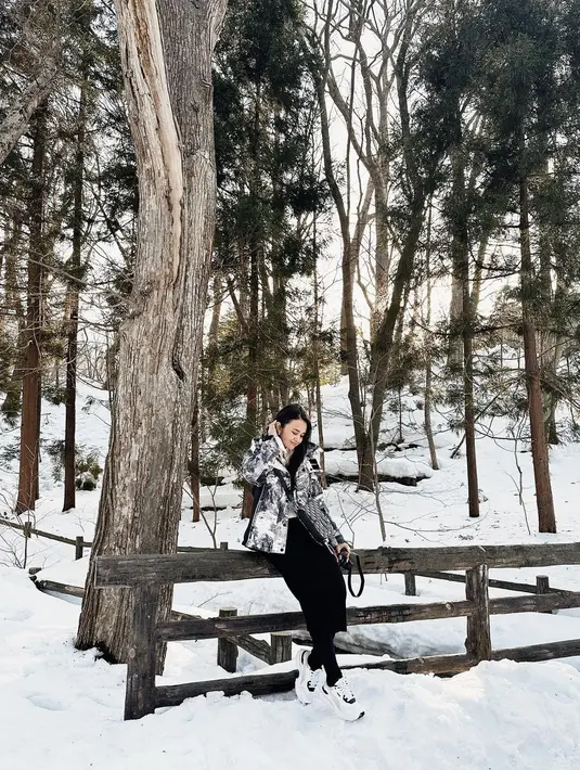 Berpose di salju, Michelle juga memesona dalam outfit winternya. Mengenakan jaket bermotif tie dye hitam-putih, dipadu dengan celana panjang hitam, ia tampak menenteng tas bernuansa senada, dan mengenakan sneakers putih yang tak pernah salah dipadu dengan outfit apapun. Foto: Instagram.