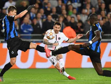 Pemain Paris Saint-Germain Lionel Messi (tengah) berebut bola dengan pemain Club Brugge pada pertandingan Grup A Liga Champions di Stadion Jan Breydel, Bruges, Belgia, Rabu (15/9/2021). Pertandingan berakhir imbang 1-1. (JOHN THYS/AFP)