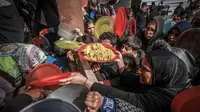 Warga Palestina yang mengungsi berkumpul untuk menerima makanan di sebuah sekolah pemerintah di Rafah di Jalur Gaza selatan pada 19 Februari 2024. (MOHAMMED ABED/AFP)