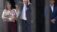 Presiden Peru Pedro Pablo Kuczynski melambaikan tangan sambil menggunakan ponselnya sebelum meninggalkan House of Pizarro, di Lima, Peru (21/3). Keputusan itu diambil di saat opisisi ingin menggulingkannya atas tuduhan korupsi. (AP/Martin Mejia)