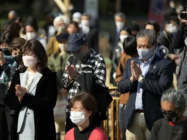 Pengunjung berdoa mengheningkan cipta untuk para korban gempa dan tsunami 11 Maret 2011 dalam acara peringatan khusus di Tokyo, Jumat (11/3/2022). Jepang menandai peringatan 11 tahun gempa bumi, tsunami dan bencana nuklir yang melanda pantai timur laut Jepang. (AP Photo/Eugene Hoshiko)