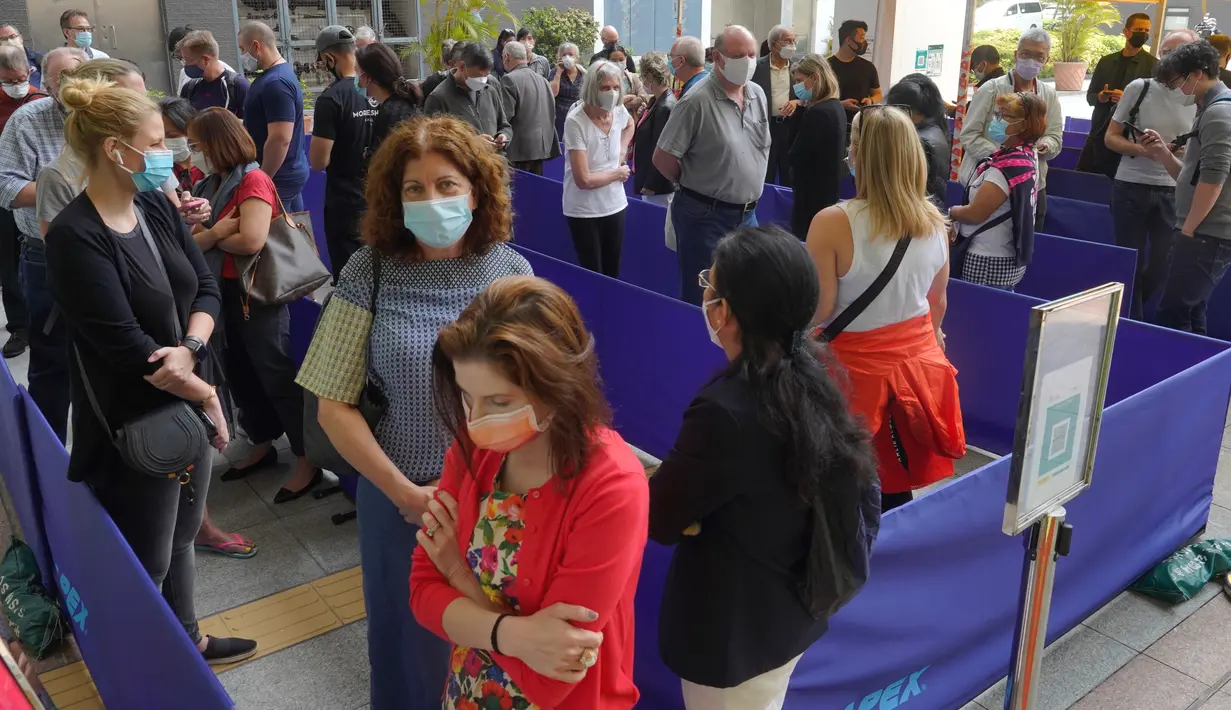 Antrean orang-orang di luar pusat vaksinasi untuk BioNTech di Hong Kong pada Rabu (24/3/2021). Hong Kong untuk sementara menangguhkan penggunaan vaksinasi corona Covid-19 Pfizer/BioNTech karena laporan kerusakan pada pengemasan botol vaksin. (AP Photo/Vincent Yu)