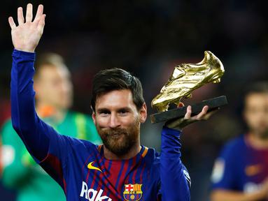 Pemain bintang Barcelona, Lionel Messi memamerkan Sepatu Emas Eropa sebelum melawan Deportivo La Coruna dalam pertandingan liga Spanyol di stadion Camp Nou di Barcelona (17/12). (AP Photo/Manu Fernandez)