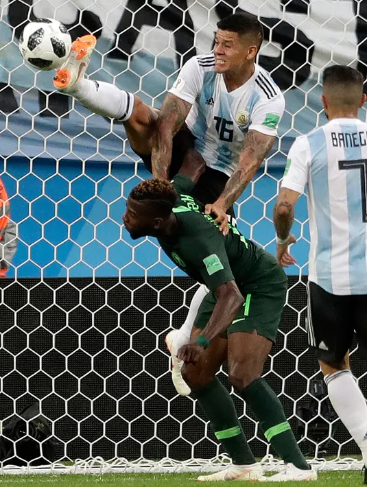 Pemain Argentina Marcos Rojo melompati pemain Nigeria Kelechi Iheanacho untuk merebut bola pada matchday terakhir Grup D Piala Dunia 2018 di Stadion St Petersburg, Selasa (26/6). Argentina meraih tiket ke 16 besar setelah menang 2-1. (AP/Petr David Josek)