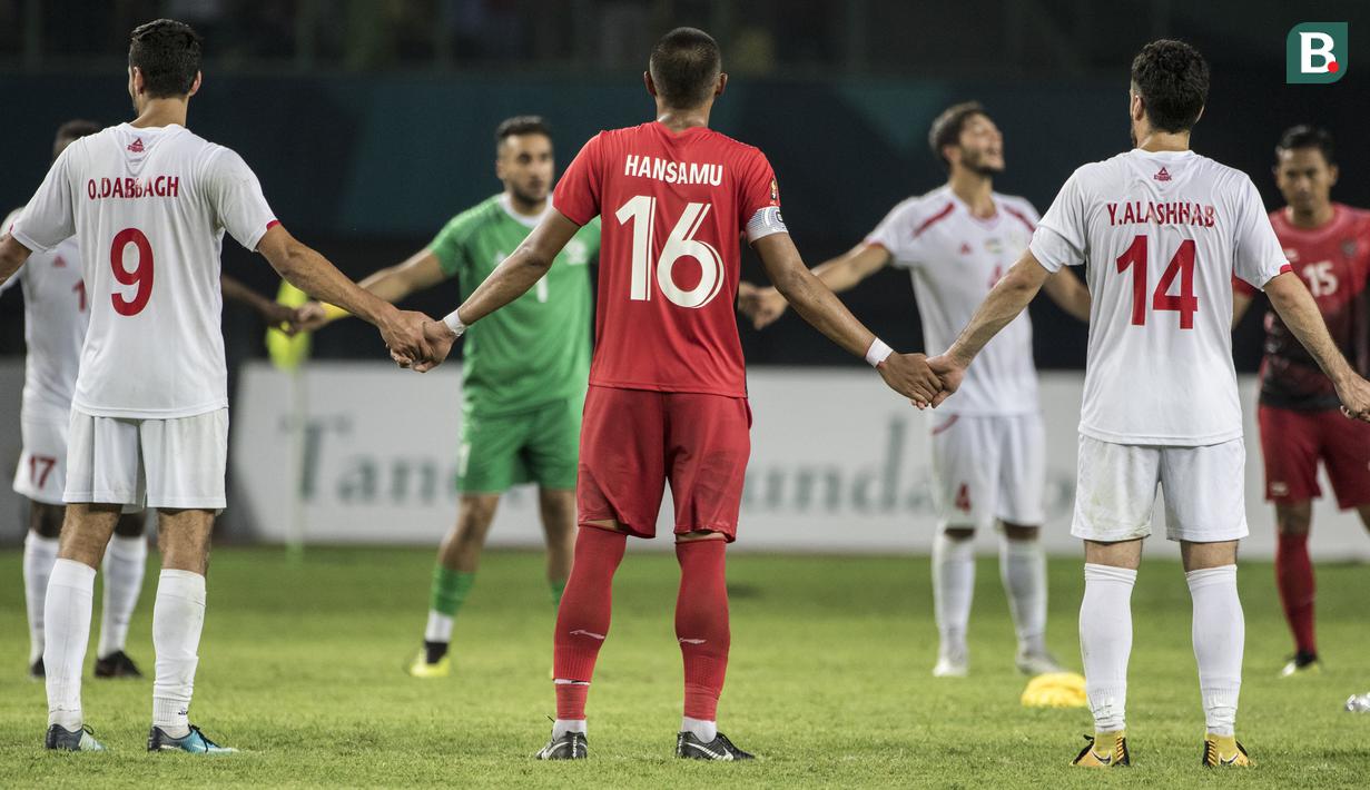 Pemain Indonesia dan Palestina berpegangan tangan pada laga Asian Games di Stadion Patriot, Jawa Barat, Rabu (15/8/2018). Indonesia takluk 1-2 dari Palestina. (Bola.com/Vitalis Yogi Trisna)
