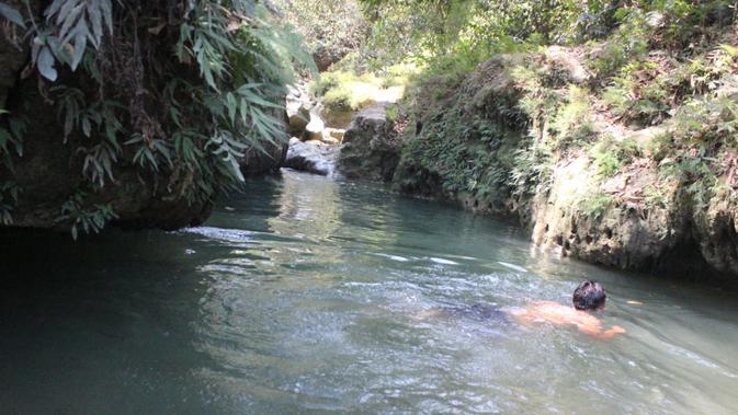 Kedung Londo sendiri merupakan aliran sungai alami yang lokasinya berada di tengah hutan. Airnya yang jernih dikelilingi bebatuan cadas besar dengan vegetasi yang padat, membuat lokasi ini cocok untuk relaksasi. (Liputan6.com/ Ahmad Adirin)
