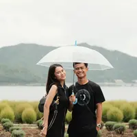 Lihat potret gemas Zize dan Arhan saat payungan berdua. Keduanya tampil serasi dengan outfit serba hitam. [@pratamaarhan8/@azizahsalsha_]