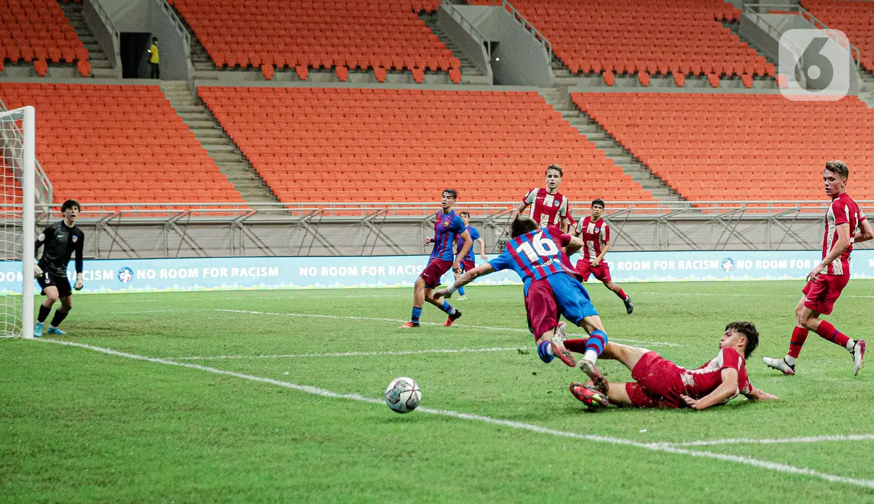 Pemain Barcelona U-18 Xavier Moreno Hernández dihalau pemain Altetico Madrid U-18 pada pertandingan International Youth Championship (IYC) 2021 di Jakarta International Stadium (JIS), Jakarta, Selasa (19/4/2022). Barcelona U-18 menang 1-0. (Liputan6.com/Faizal Fanani)