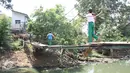 Sejumlah pelajar melintasi Kali Angke menggunakan jembatan rapuh di Kampung Cantiga, Petir, Cipondoh, Tangerang, Rabu (2/9/2015). Jembatan berusia lima tahun tersebut menghubungkan Cipondoh dan Kembangan, Jakarta. (Liputan6.com/Gempur M Surya)