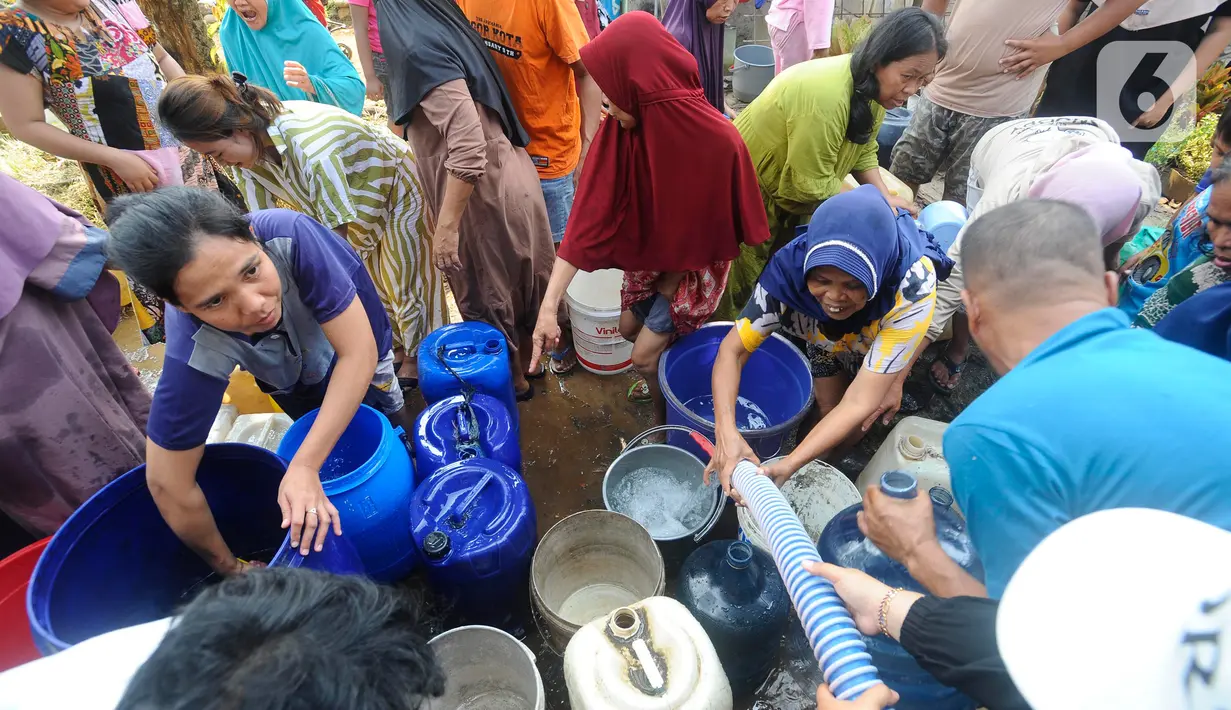 Tak hanya itu, selang besar dari truk tangki air bersih pun tampak dipegang secara beramai-ramai oleh warga yang saling membutuhkan. (merdeka.com/Arie Basuki)