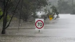Rambu-rambu lalu lintas terendam di sepanjang jalan yang banjir di Londonderry di pinggiran Sydney, Australia, Senin (4/7/2022). Banjir kali ini merupakan yang terparah bagi kota terbesar di Australia tersebut selama 18 bulan terakhir. (AP Photo/Mark Baker)