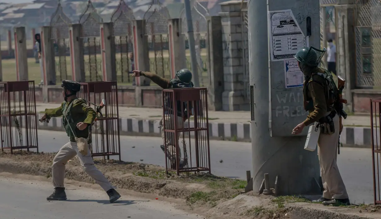 Tentara paramiliter India membawa batu selama bentrok dengan pengunjuk rasa selama protes terhadap pembunuhan pemberontak di Srinagar, Kashmir yang dikuasai India, (1/4). (AP Photo / Dar Yasin)