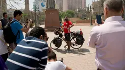 Pria Mesir, Mohammed Nufal berpose sebelum menuju Rusia menggunakan sepeda dari Tahrir Square di Kairo, Sabtu (7/4). Nufal menempuh jarak ribuan kilometer untuk melihat Timnas Mesir bertanding di Piala Dunia setelah absen selama 28 tahun. (AP/Amr Nabil)