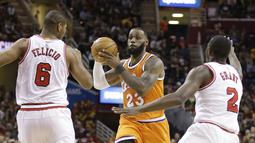 Pemain Cleveland Cavaliers, LeBron James (23) berusaha melewati hadangan para pemain Chicago Bulls pada aga NBA basketball game di Quicken Loans Arena, Cleveland. (AP/Tony Dejak)