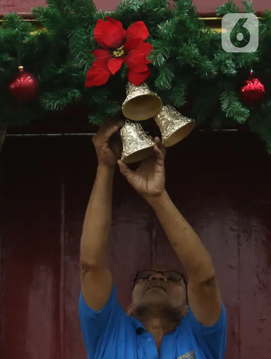 Pekerja merapikan ornamen Natal di Gereja Tugu, Jakarta, Senin (23/12/2019). Sejumlah perlengkapan ibadah telah disiapkan untuk menyambut Natal. (Liputan6.com/Herman Zakharia)