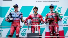 Pemenang pembalap Italia Enea Bastianini (tengah), pembalap Spanyol peringkat kedua Alex Marquez (kiri), dan pembalap Italia peringkat ketiga Francesco Bagnaia berpose untuk fotografer di podium balapan MotoGP Malaysia 2023 di Sepang, Malaysia Minggu (12/11/2023). (AP Photo/Vincent Thian)