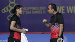 Pebulutangkis Indonesia, Gregoria Mariska, mendapatkan instruksi saat melawan Ratchanok Intanon pada final beregu putri SEA Games 2019 di Muntinlupa Sports Complex, Manila, Selasa (3/12). Kalah 1-3, Indonesia hanya meraih perak. (Bola.com/M Iqbal Ichsan)