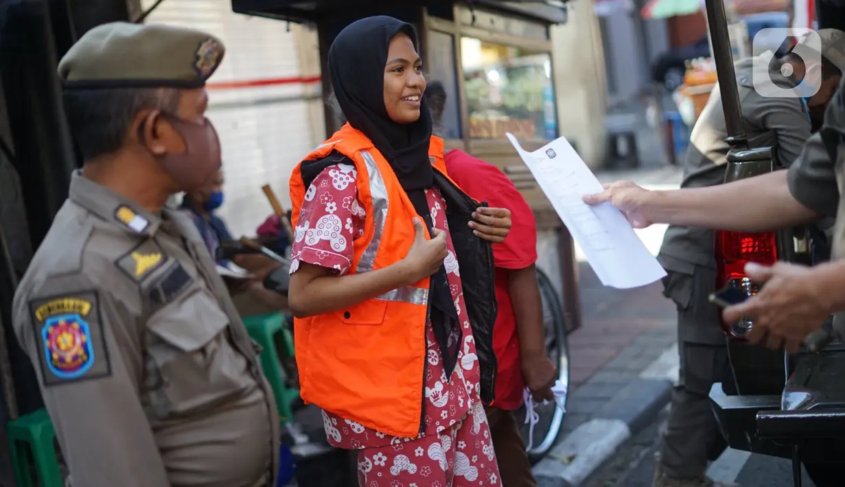 Petugas Satpol PP memberikan sanksi menyapu kepada warga yang tidak menggunakan masker di kawasan Pasar Baru, Jakarta, Jumat (21/8/2020). Sanksi tersebut dilakukan sebagai bagian dari upaya pencehagan penyebaran virus covid-19. (Liputan6.com/Immanuel Antonius)