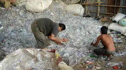 Pengumpul sampah memilih botol plastik di sebuah gudang sampah di Nusa Dua, di pulau resor Indonesia Bali (2/5). (AFP Photo/Sonny Tumbelaka)